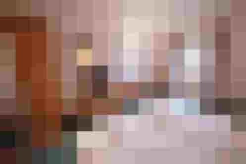 Gemütliches Schlafzimmer mit TV, Holzschränken und Blick auf die Alpen. Ideal für den Urlaub.