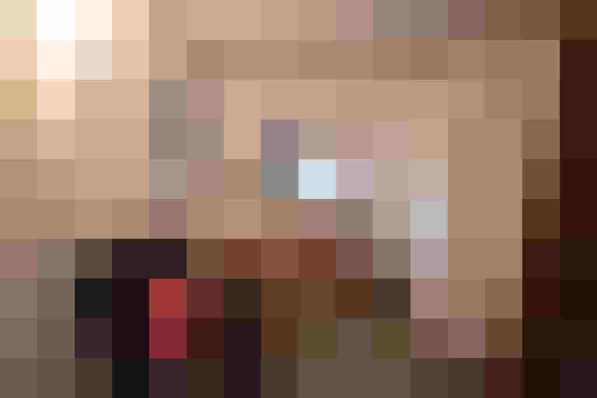 Heller Flur mit gemütlichem Sessel, Holzkommode und Fenster im Ferienapartment.